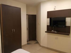 a hotel room with a television and a bedroom at Hotel Red Hut Chandigarh railway station in Zirakpur