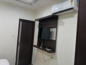 a room with a bed and a tv and a door at Hotel Red Hut Chandigarh railway station in Zirakpur
