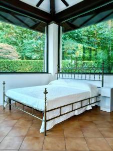 a bed in a room with a large window at Il giardino delle cince in Borgo Ticino