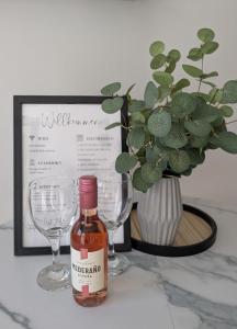 a bottle of wine next to two wine glasses at Ferienwohnung in Ranzig - klein aber fein in Tauche