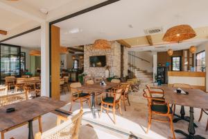 an empty restaurant with wooden tables and chairs at Val D'or Olive Village in Ulcinj