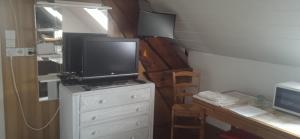 a tv on top of a dresser with a desk at Chambre à la campagne ,au Soleil levant in Achiet-le-Grand +8 photos