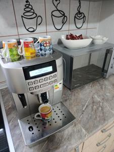 a coffee machine with cups on a counter at Vikend kuća Konjic in Konjic