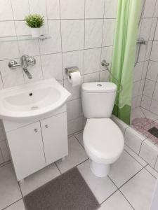 a white bathroom with a toilet and a sink at Obłoczek in Łeba +52 photos