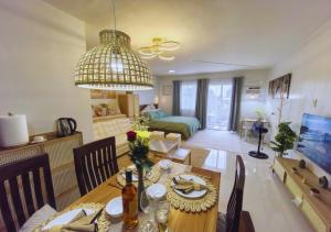a dining room and living room with a dining table at Spacious Studio w Pool, Gym, Smart Lock, Netflix in Puerto Princesa City
