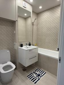 a bathroom with a toilet and a sink and a tub at Blue Oasis Apartment - Hils Brauner in Bucharest
