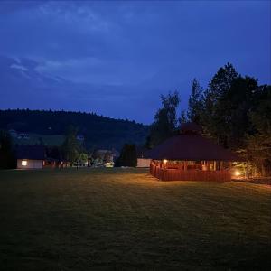 a gazebo with lights in a field at night at Podgórskie Zacisze in Bodzentyn