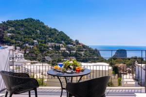 a table on a balcony with a view of the ocean at Regina Cristina in Capri