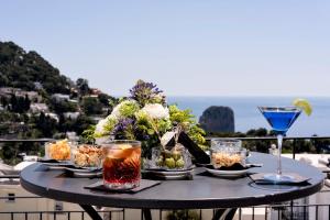 a table with drinks on it with a view of the ocean at Regina Cristina in Capri