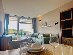 a living room with a table with wine glasses at Villa Anna I - Wohnung Strandjunge in Sankt Peter-Ording