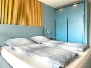 a bed with two pillows on it in a room at Villa Anna I - Wohnung Strandjunge in Sankt Peter-Ording