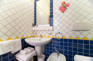 uma casa de banho azul e branca com um lavatório e um WC em Riviera Residence em Rimini