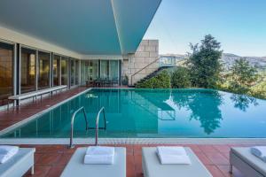 a swimming pool in the middle of a house at Infinity Villa Cavez - Luxury Retreat in Moimenta