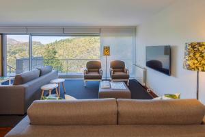 a living room with a couch and chairs at Infinity Villa Cavez - Luxury Retreat in Moimenta