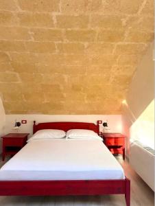 a bedroom with a red bed and two night stands at Residence Del Casalnuovo in Matera