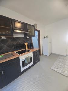 a kitchen with a stove and a white refrigerator at Simple Modern Apartment in Duisburg +8 photos