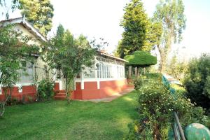 a house with a yard with a green grass at Wyoming Heritage in Ooty