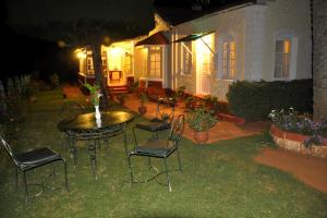 a patio with a table and chairs in front of a house at Wyoming Heritage in Ooty