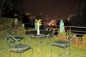 a table and chairs with a vase of flowers on it at Wyoming Heritage in Ooty
