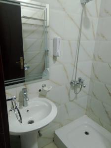 a white bathroom with a sink and a shower at فندق بلورة البشاير in An Naqāʼ +19 photos