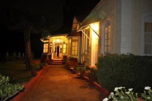 a house with lights on the front of it at night at Wyoming Heritage in Ooty