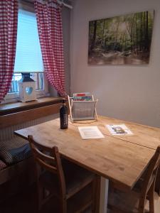 a wooden table in a room with two chairs and a window at Ferienhaus Schönek in Warmensteinach +3 photos