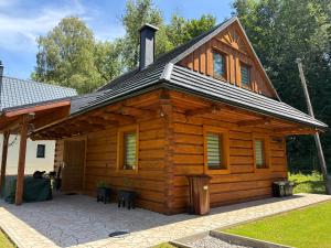 a log cabin with a roof on a patio at Chata v Oščadnici - Slniečko in Čadca