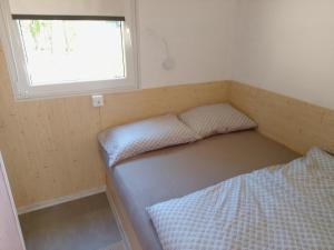 a small room with a bed and a window at Tiny house TIA in Nova Gorica