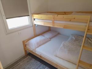 two bunk beds in a small room with a window at Tiny house TIA in Nova Gorica