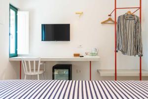a bedroom with a bed and a desk and a tv at Casale Santa Rosalia Charme Villas and Rooms in San Mauro Cilento