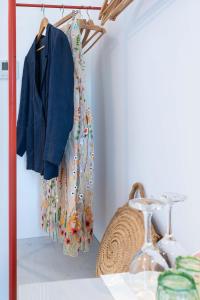 a closet with a rack with a blue jacket and a basket at Casale Santa Rosalia Charme Villas and Rooms in San Mauro Cilento +111 photos