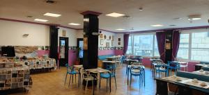 a restaurant with tables and chairs in a room at Hotel Nuevo Cachalote in Portonovo