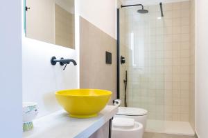 a bathroom with a yellow bowl on a counter at Casale Santa Rosalia Charme Villas and Rooms in San Mauro Cilento