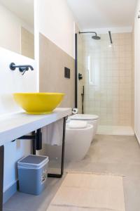 a bathroom with a yellow sink and a toilet at Casale Santa Rosalia Charme Villas and Rooms in San Mauro Cilento