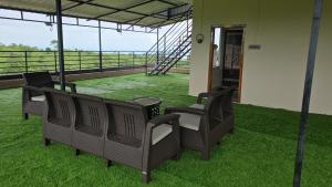 a group of chairs on a balcony with green grass at Hame Lana Resort in Mawlynnong