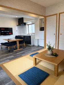 a living room with a table and a kitchen at GLANZ KEI Kyoto Station in Kyoto +86 photos