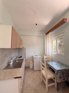 a kitchen with a table and a sink and a table and chairs at Eden Apartments in Qeparo