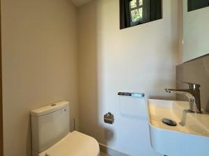 a bathroom with a white toilet and a sink at Verdant Horizon in Moka