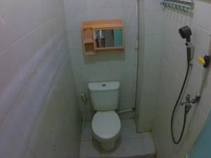 a small bathroom with a toilet and a shower at Taba Yama Trip & Homestay in Ketapang