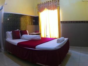 a large bed in a room with a window at Taba Yama Trip & Homestay in Ketapang