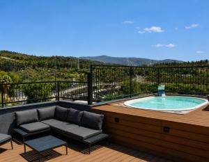 a hot tub on a deck with a couch and chairs at בוטיק אשתאול - 4 סוויטות מפנקות עם ג'קוזי פרטי ו2 בריכות במתחם in Eshtaol