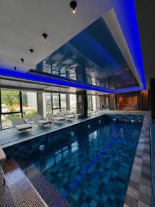 a large swimming pool in a building with blue lighting at The New Jai Son in Kobuleti