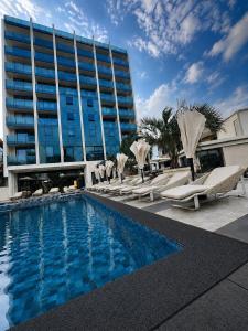 a hotel with a pool and lounge chairs and a building at The New Jai Son in Kobuleti