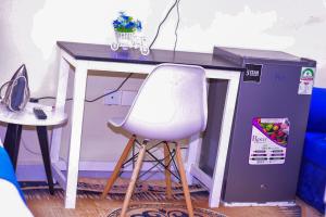 a white chair sitting in front of a desk at Des Homes in Nairobi