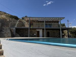 a villa with a swimming pool in front of a building at Stone Villa, Infinity Pool & Libyan Sea Views in Agia Galini
