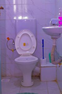 a bathroom with a toilet and a sink at Des Homes in Nairobi