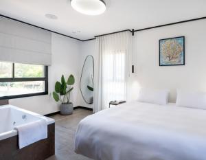 a bedroom with a large bed and a bath tub at בוטיק אשתאול - 4 סוויטות מפנקות עם ג'קוזי פרטי ו2 בריכות במתחם in Eshtaol