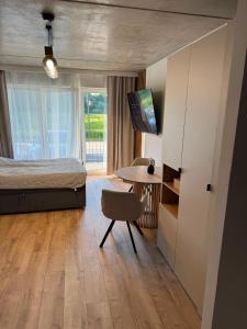 a bedroom with a bed and a table with a chair at Róża- Lotnisko in Wrocław