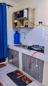 a kitchen with a sink and a stove at Des Homes in Nairobi