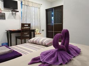 a pair of purple towels sitting on top of a bed at OCEAN LODGE in Pantai Cenang +62 photos